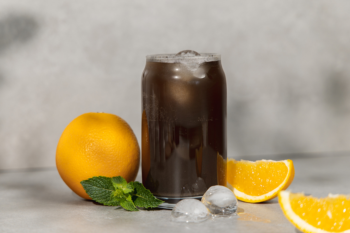 Männerpower Getränk Cola-Orange in einem Glas mit Eiswürfeln