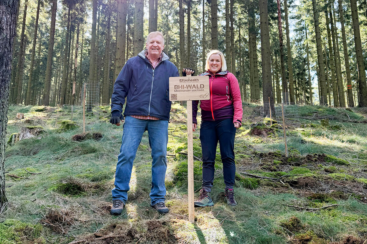 Dr. Peter Pfeilschifter und Julia Krügel hinter BHI-Wald-Schild