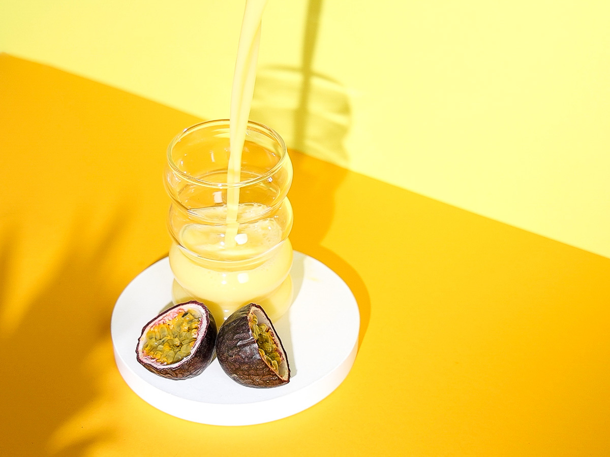 Halb volles Glas, in welches Mellow Yellow Drink eingegossen wird